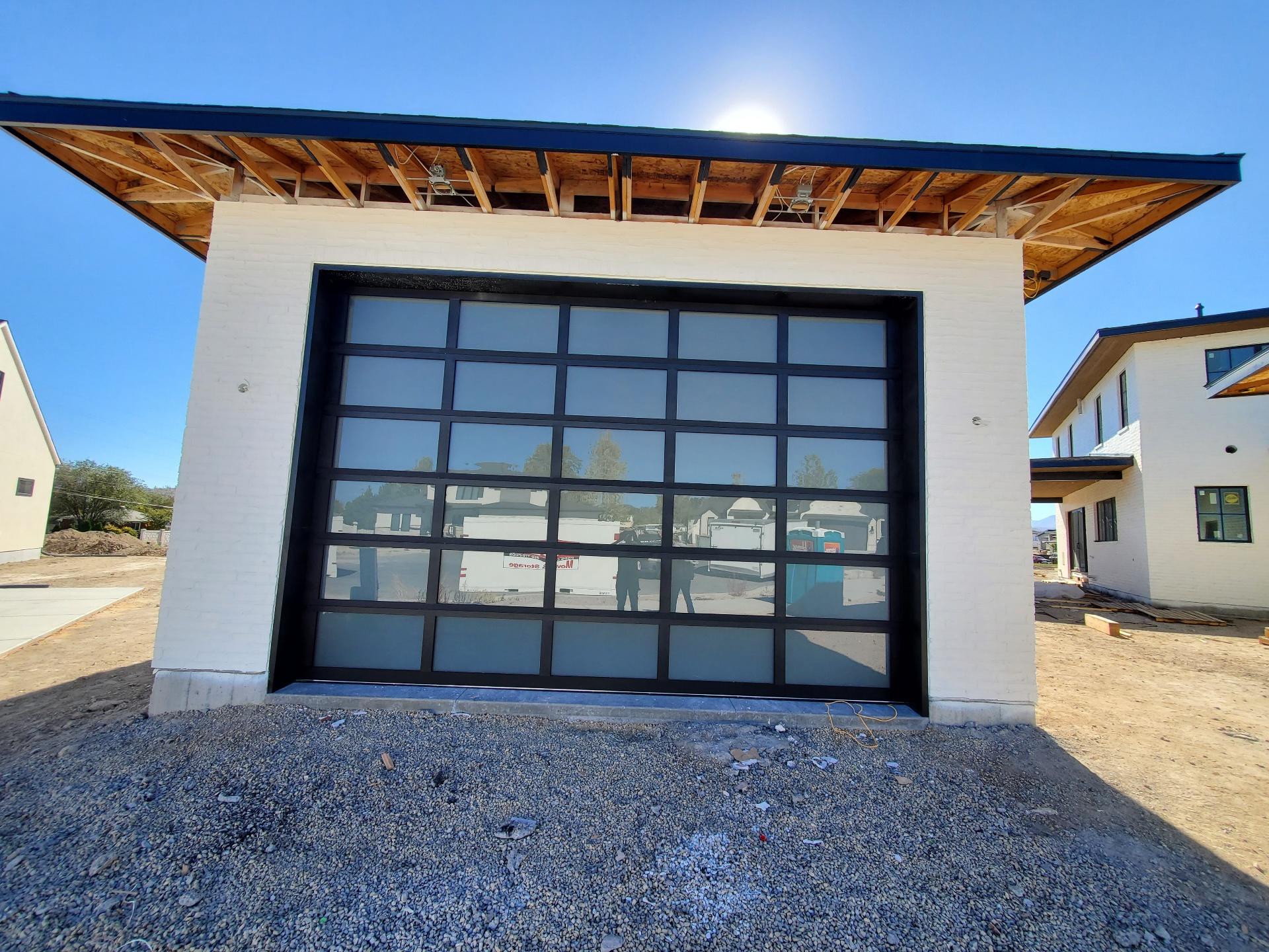 Black-framed glass garage door on a home under construction