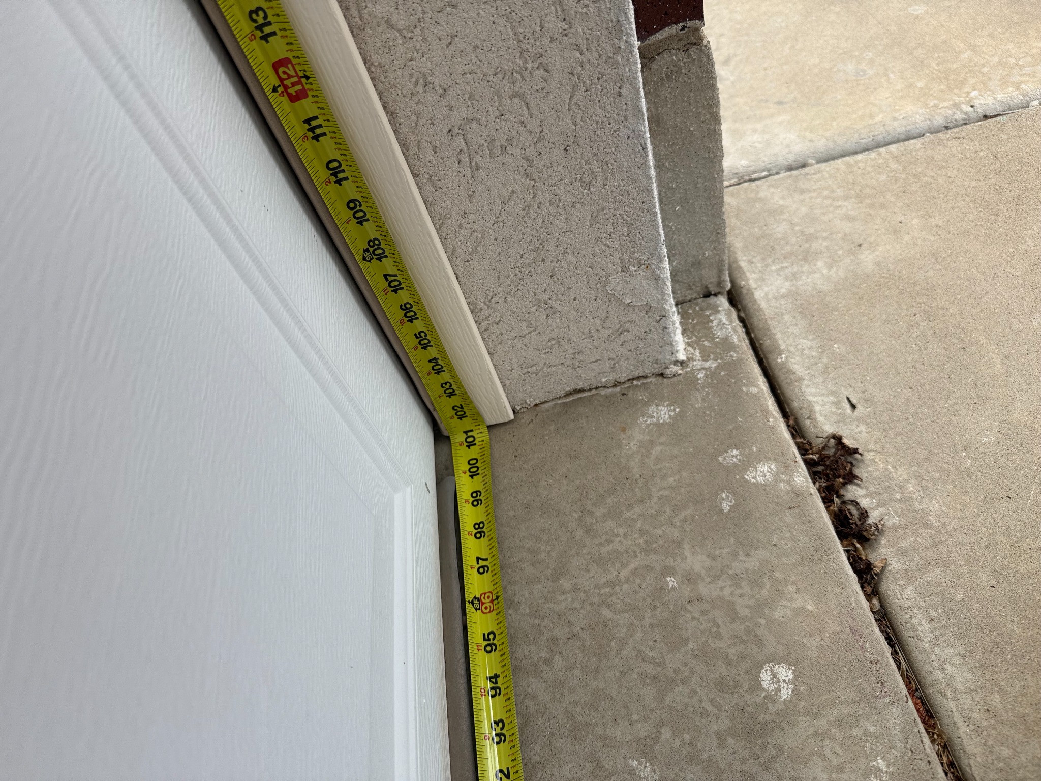 Tape measure beside a white garage door and its frame